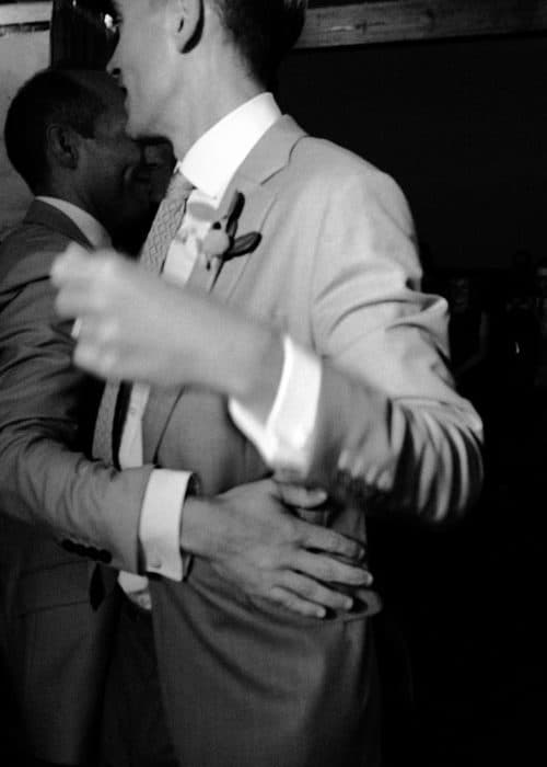 grooms holding each other at wedding