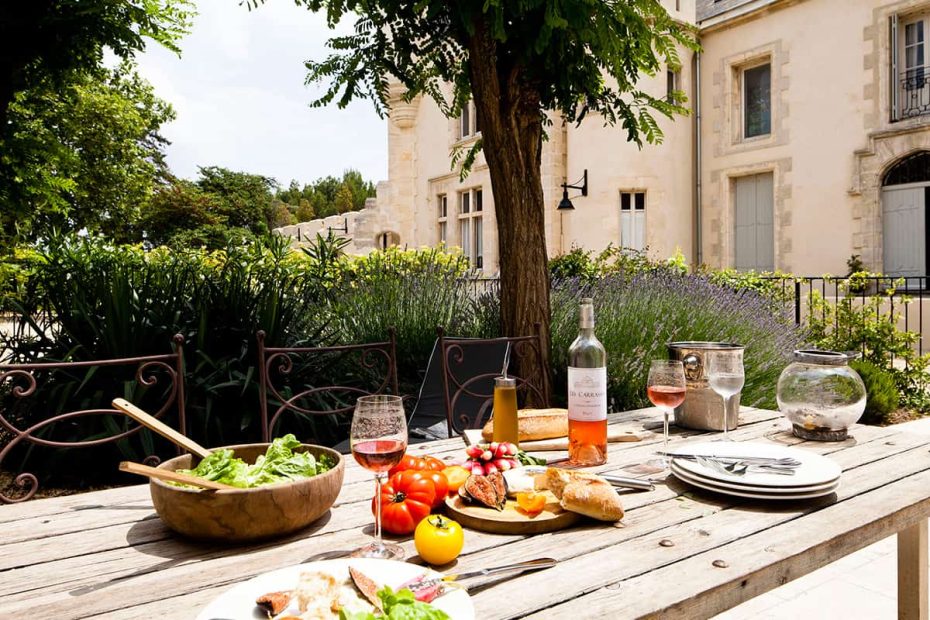 wine and salad on table outside chateau les carrasses wedding venue