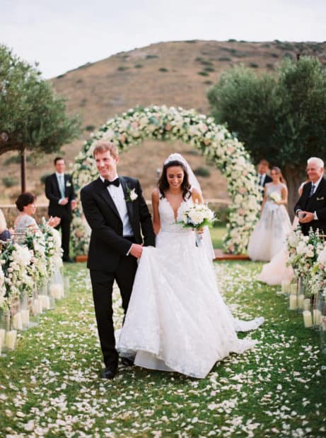 bride and groom stroll over petals
