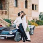 bride and groom kiss near wedding car