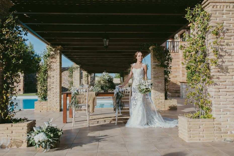 bride holding bouquet near pool