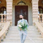 fashionably dressed groom holding flowers
