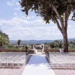 white aisle leading to wedding arch with a stunning view