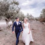 newly weds walk through olive grove