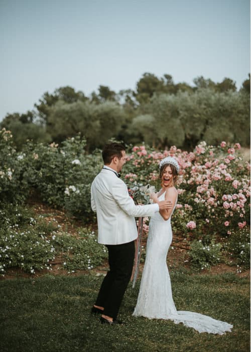 bride and groom laughing in flower garden