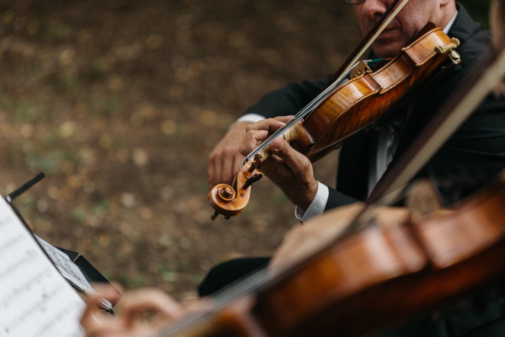 close up of violinists performing at wedding