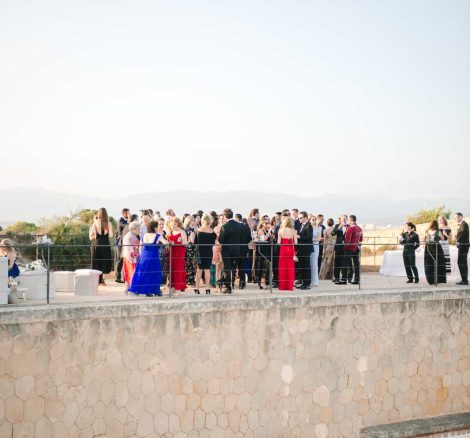 wedding guests mingle on balcony at cap rocat wedding venue in mallorca spain