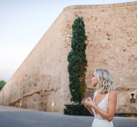 Bride Kat wearing her wedding dress stood on the grounds of cap rocat, a beautiful wedding venue in Mallorca