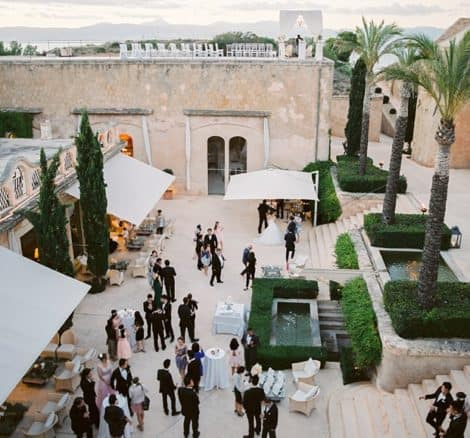 wedding guests gathered in courtyard plaza at cap rocat wedding venue in Majorca spain