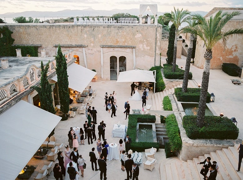 wedding guests gathered in courtyard plaza at cap rocat wedding venue in Majorca spain