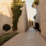sandstone walkway with green shrubs and trees at cap rocat wedding venue in mallorca spain