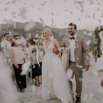 bride and groom walk amidst white confetti