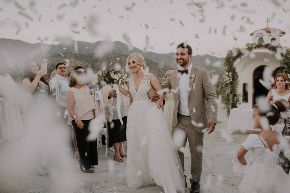 bride and groom walk amidst white confetti