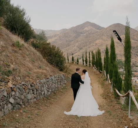 Bride and Groom walking away through the mountainous valley at Honeyli Hill Wedding Venue in Larnaca Cypruslandscape