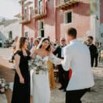 bride holds grooms hand while mother watches