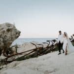 bride and groom walking next to anchors