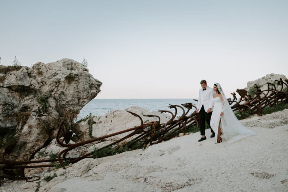 bride and groom walking next to anchors