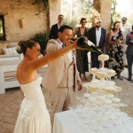 Image of couple pouring champagne into champagne tower at wedding venue Casa La Siesta