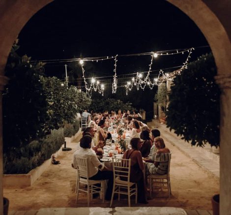 wedding guests seated for the wedding breakfast beneath twinkling white lights at spanish wedding venue case la siesta