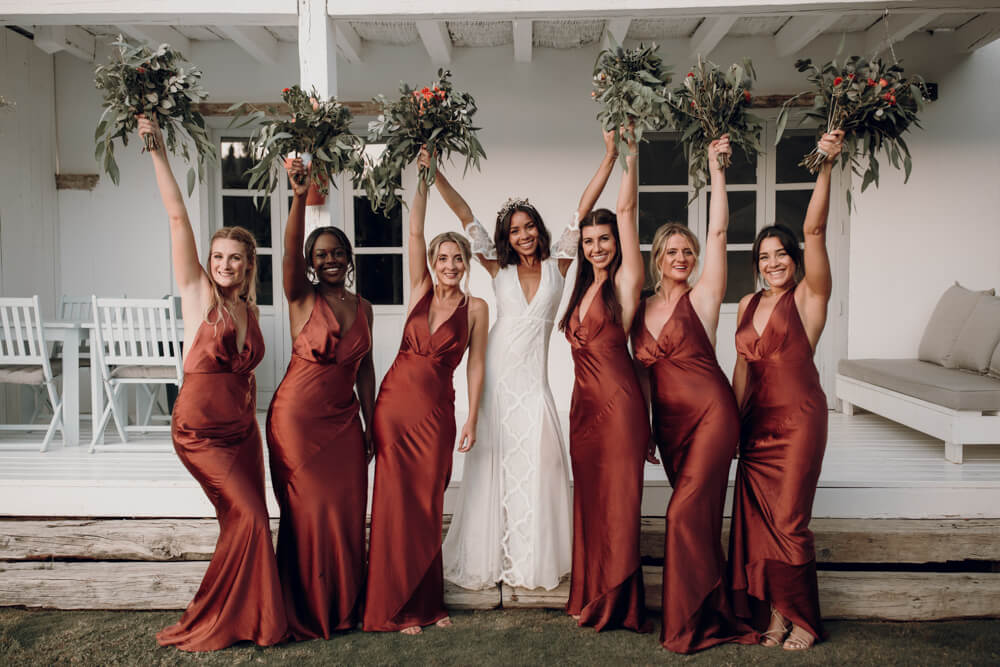 jess and her bridesmaids lifting bouquets