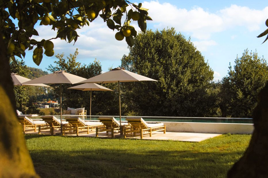 loungers by the pool area at terra rosa country house and vineyards wedding venue in portugal