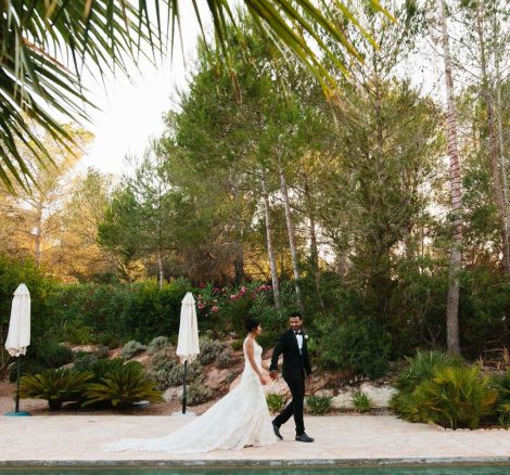 bride and groom walking through the grounds surrounded by plants at hacienda na Xamena unique wedding venue in ibiza