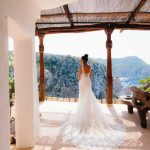 bride facing away towards the ocean in her bridal gown at hacienda na Xamena unique wedding venue in ibiza