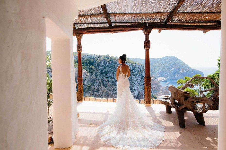 bride facing away towards the ocean in her bridal gown at hacienda na Xamena unique wedding venue in ibiza