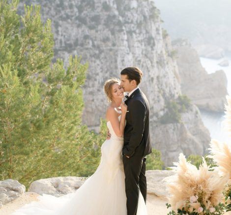 bride and groom stood together on a clifftop with spectacular views on their wedding day at hacienda na Xamena unique wedding venue in ibiza