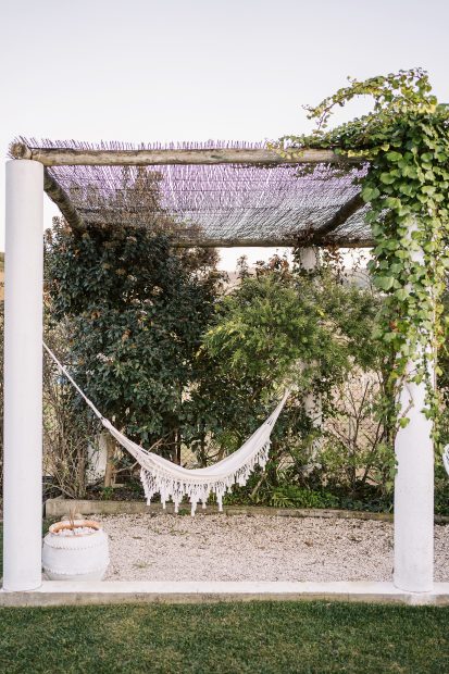canopied outdoor area with a hanging macrame hammock at wedding venue casa sacoto in portugal
