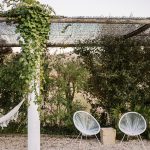 two white woven chairs underneath an outdoor canopy at wedding venue casa sacoto in portugal