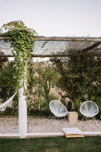 two white woven chairs underneath an outdoor canopy at wedding venue casa sacoto in portugal