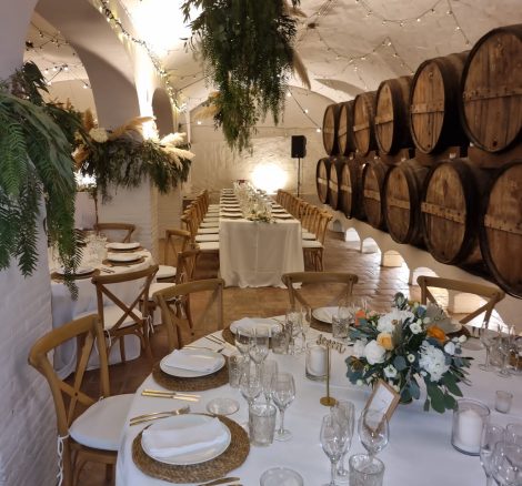 underground wine cellar with white arched ceilings decorated with pampas grass for a wedding reception at villa Catalina in spain