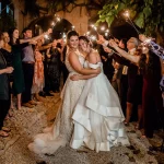 brides surrounded by family and sparklers outside at villa catalina