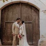bride and groom shot outside large wooden door at villa Catalina wedding venue in Barcelona Spain