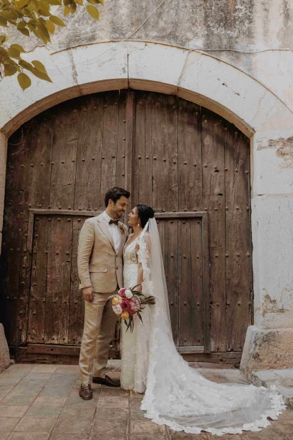 bride and groom shot outside large wooden door at villa Catalina wedding venue in Barcelona Spain
