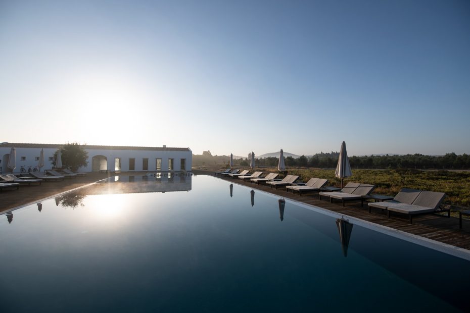 outdoor swimming pool glistening in the sunlight at craveiral farmhouse wedding venue in portugal