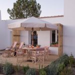 outdoor decking area with wooden table and chairs at accommodation at craveiral farmhouse in portugal