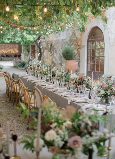 Al fresco dining tables with pastel coloured flowers at spanish wedding venue