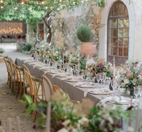 Al fresco dining tables with pastel coloured flowers at spanish wedding venue