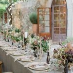 Al fresco dining tables with grey linens and white candles at spanish wedding venue