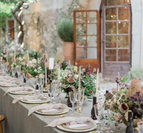 Al fresco dining tables with grey linens and white candles at spanish wedding venue