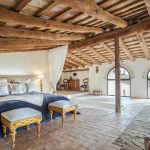 double bedroom with sloped wooden ceiling at spanish wedding venue Masia Victoria