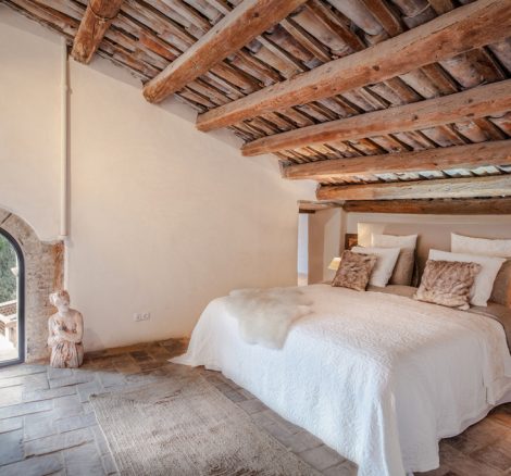 double bedroom with sloped wooden ceiling at spanish wedding venue Masia Victoria