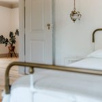 the metal bed frame and white furnishings at wedding venue casa sacoto in portugal