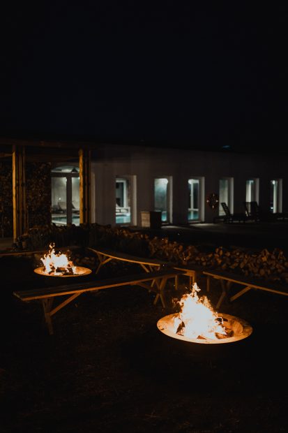 two outdoor fire pits lit on a dark evening outside craveiral farmhouse wedding venue in portugal