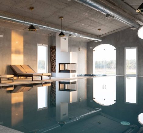 indoor pool area with arched floor top ceiling windows at carveiral farmhouse in portugal
