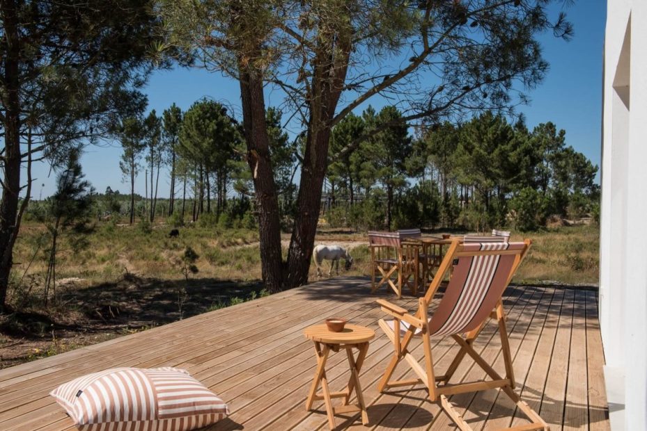 outdoor decking area with deck chairs looking out onto grounds at craveiral farmhouse portugal