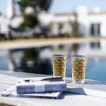 two refreshing drinks sat at the edge of the pool at craveiral farmhouse a wedding venue in portugal
