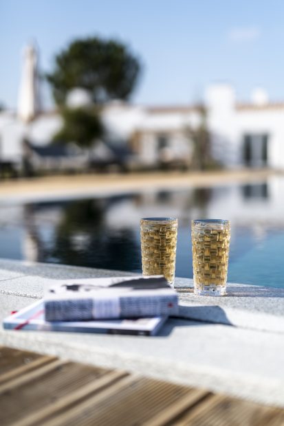 two refreshing drinks sat at the edge of the pool at craveiral farmhouse a wedding venue in portugal